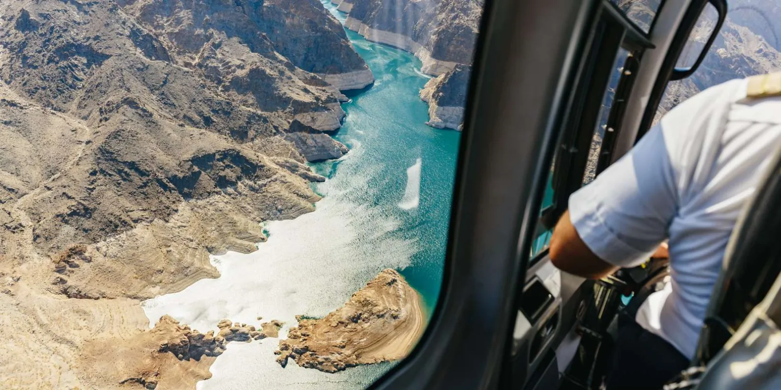 Looking down at the turquoise Colorado River through the open door of a Maverick helicopter