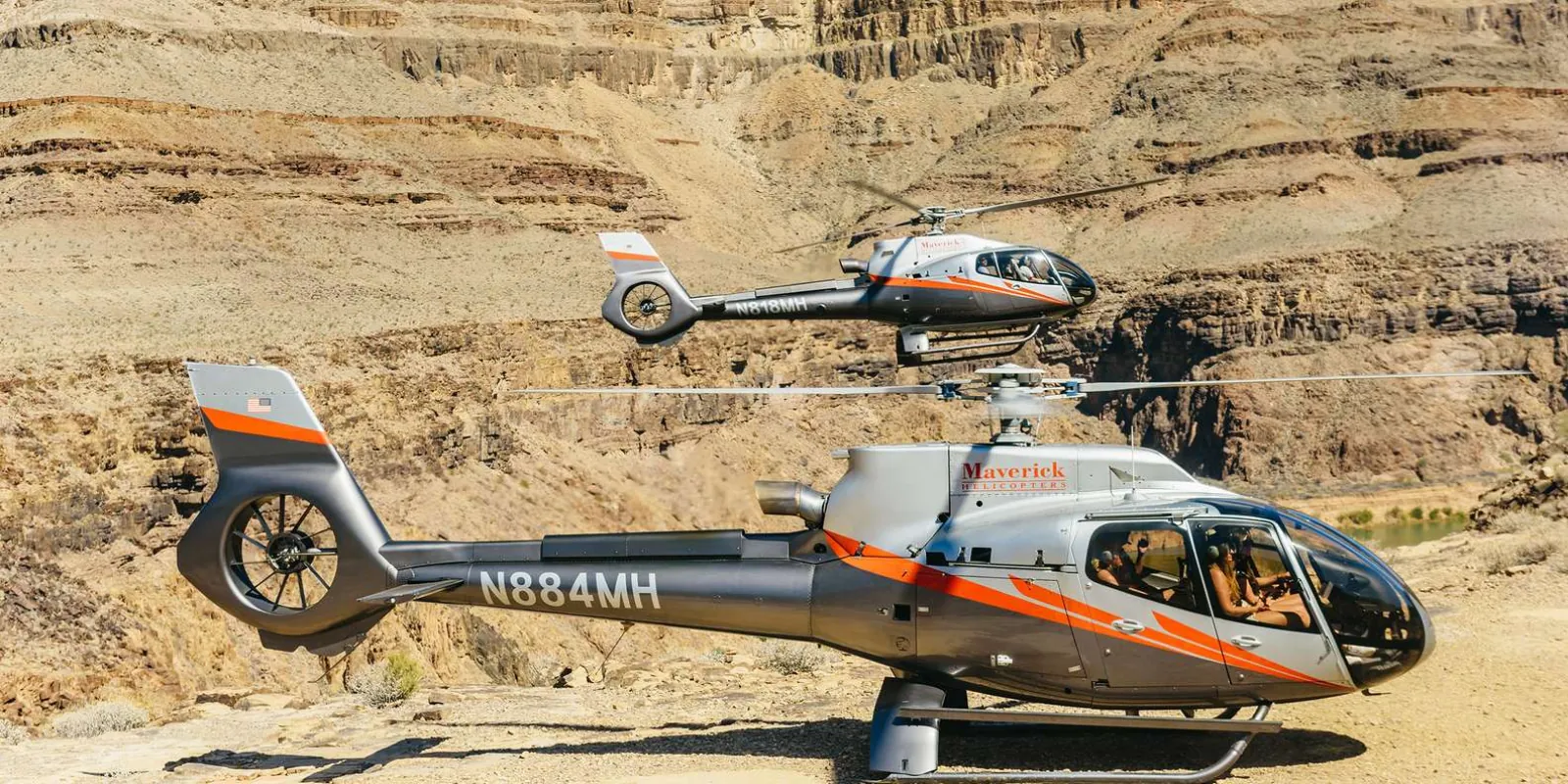 Two Maverick helicopters parked side by side on the Grand Canyon landing plateau
