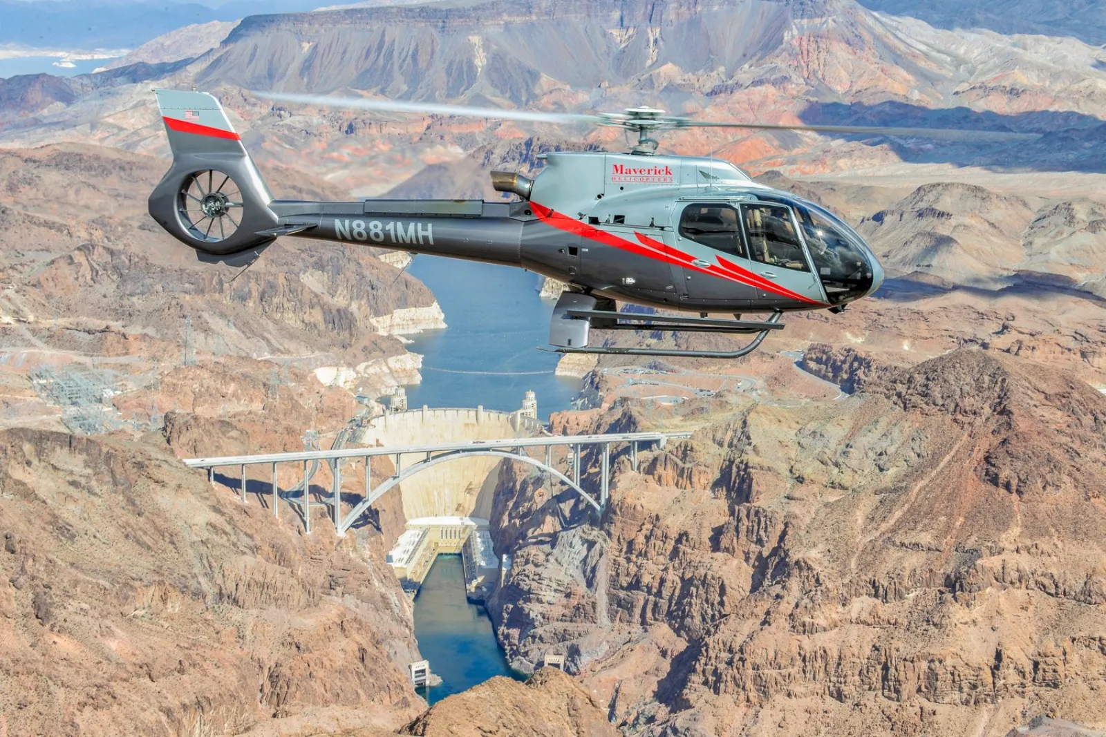 Helicopter flying over the Hoover Dam and Black Canyon en route to the West Rim