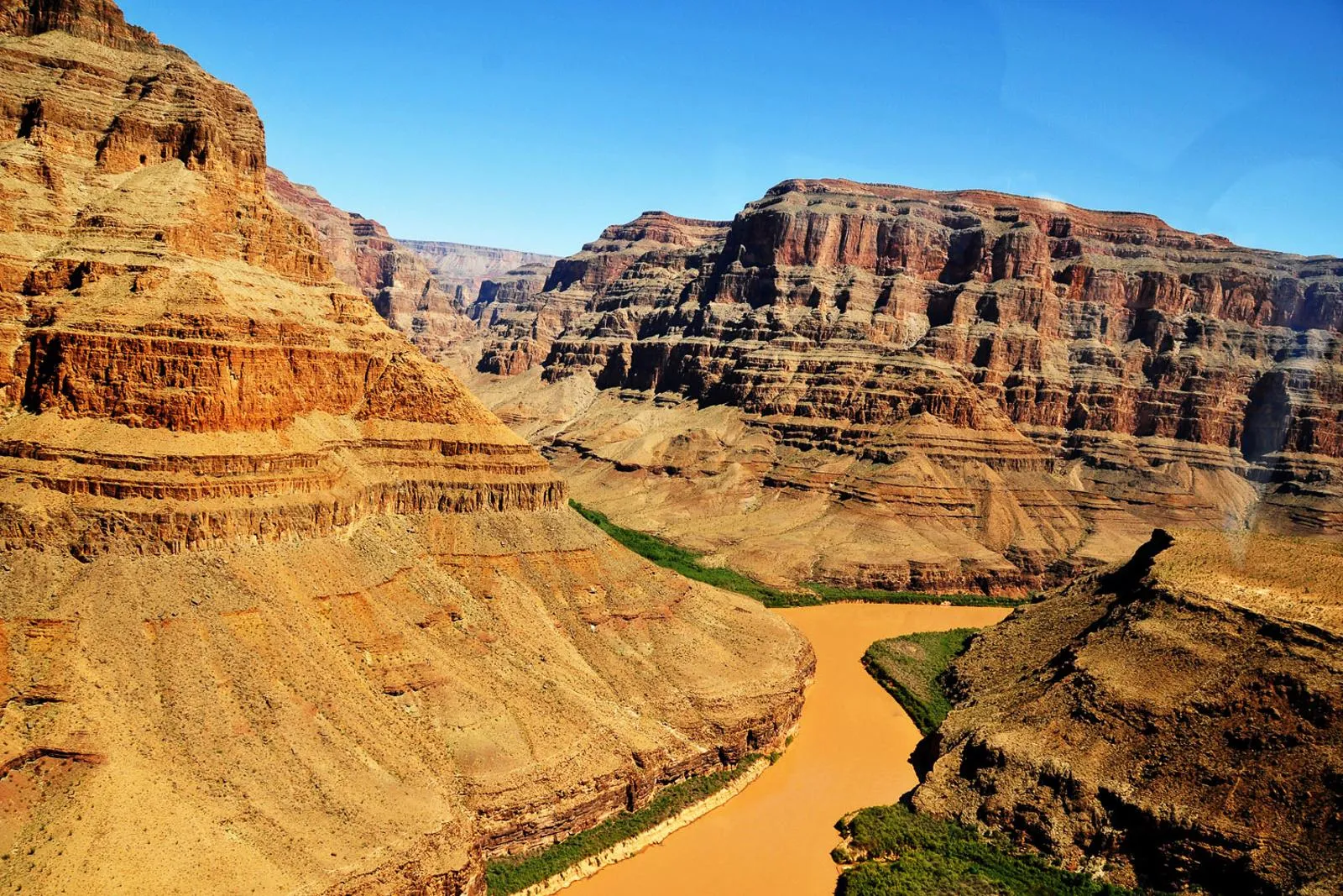 Sunlit canyon walls falling away to the Colorado River far below