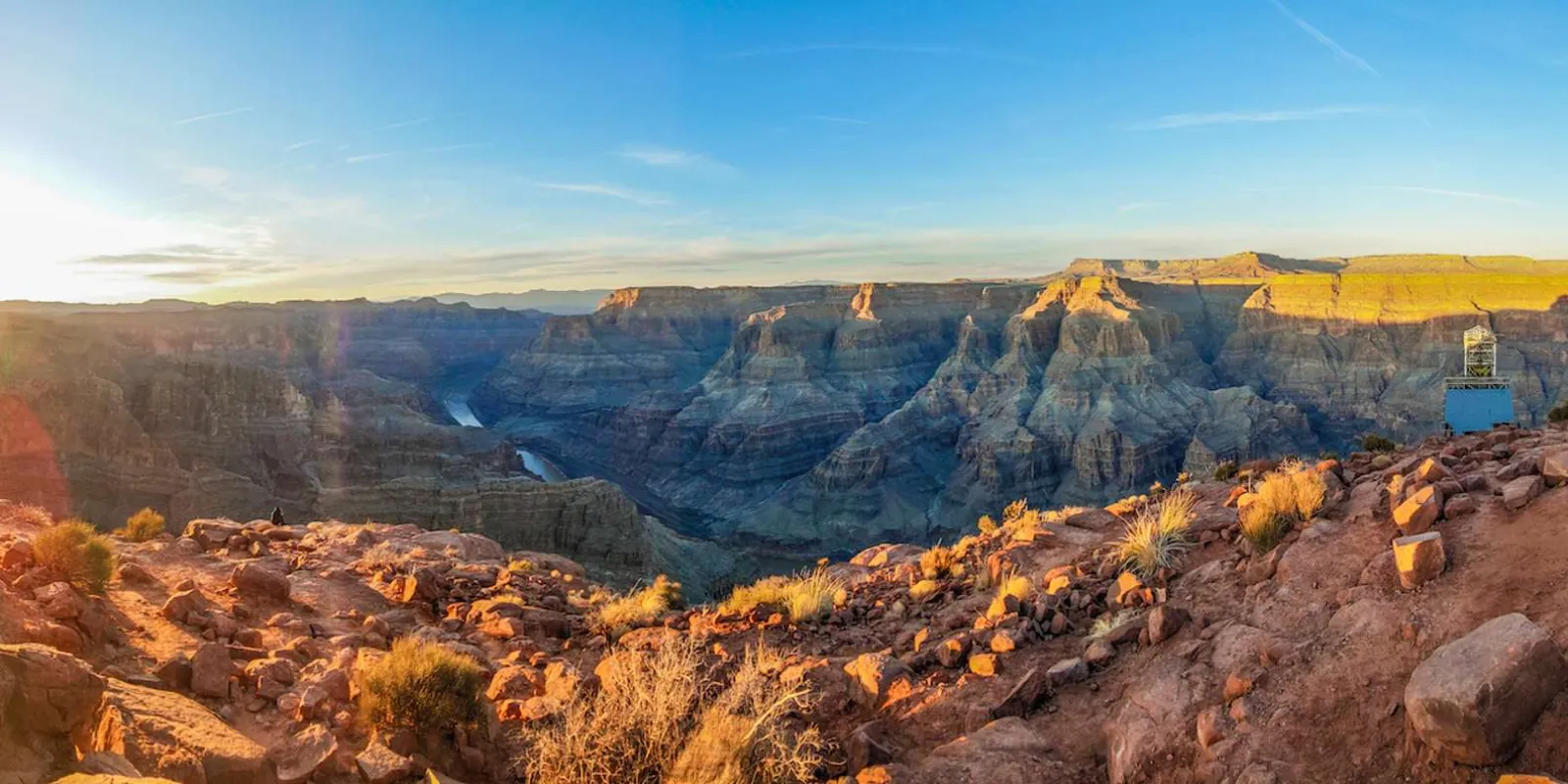 Sunrise light spilling across the Grand Canyon rim with the Colorado River below